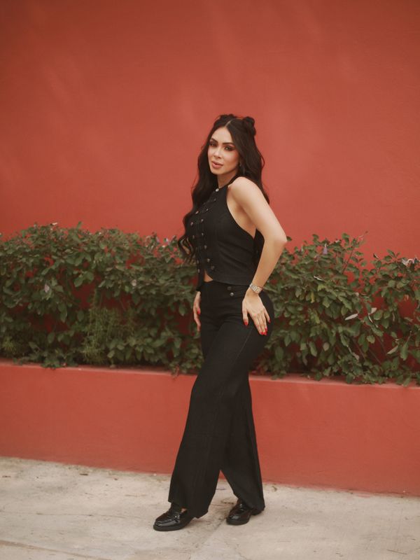 Bianca de total black frente a un muro rojo