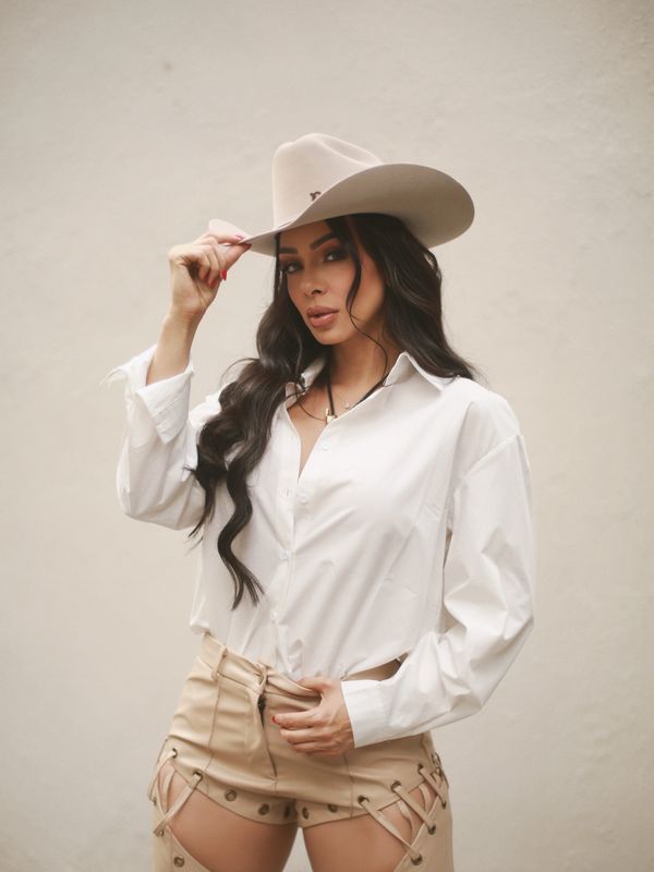 Bianca con sombrero vaquero, camisa blanca y chaparreras